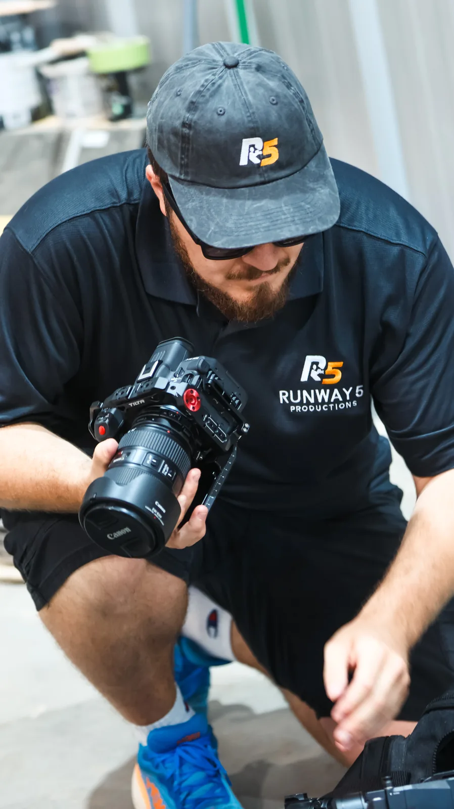 Crew member crouching to check a cinema camera between setups