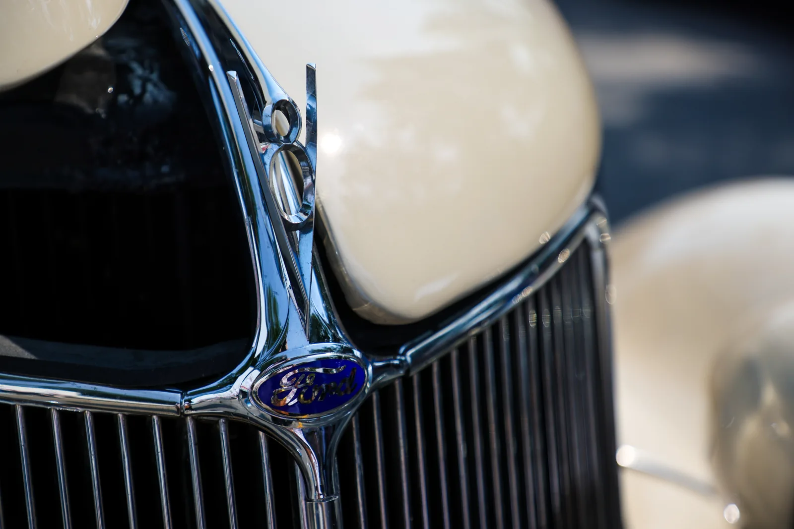 Chrome grille and V8 badge on a classic cream-coloured car