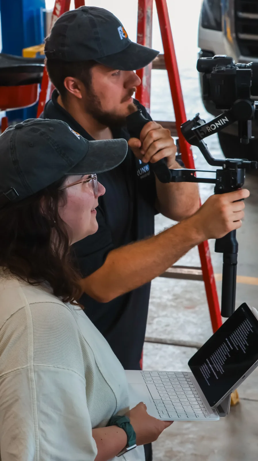 Two crew members operating a camera on a three-axis gimbal