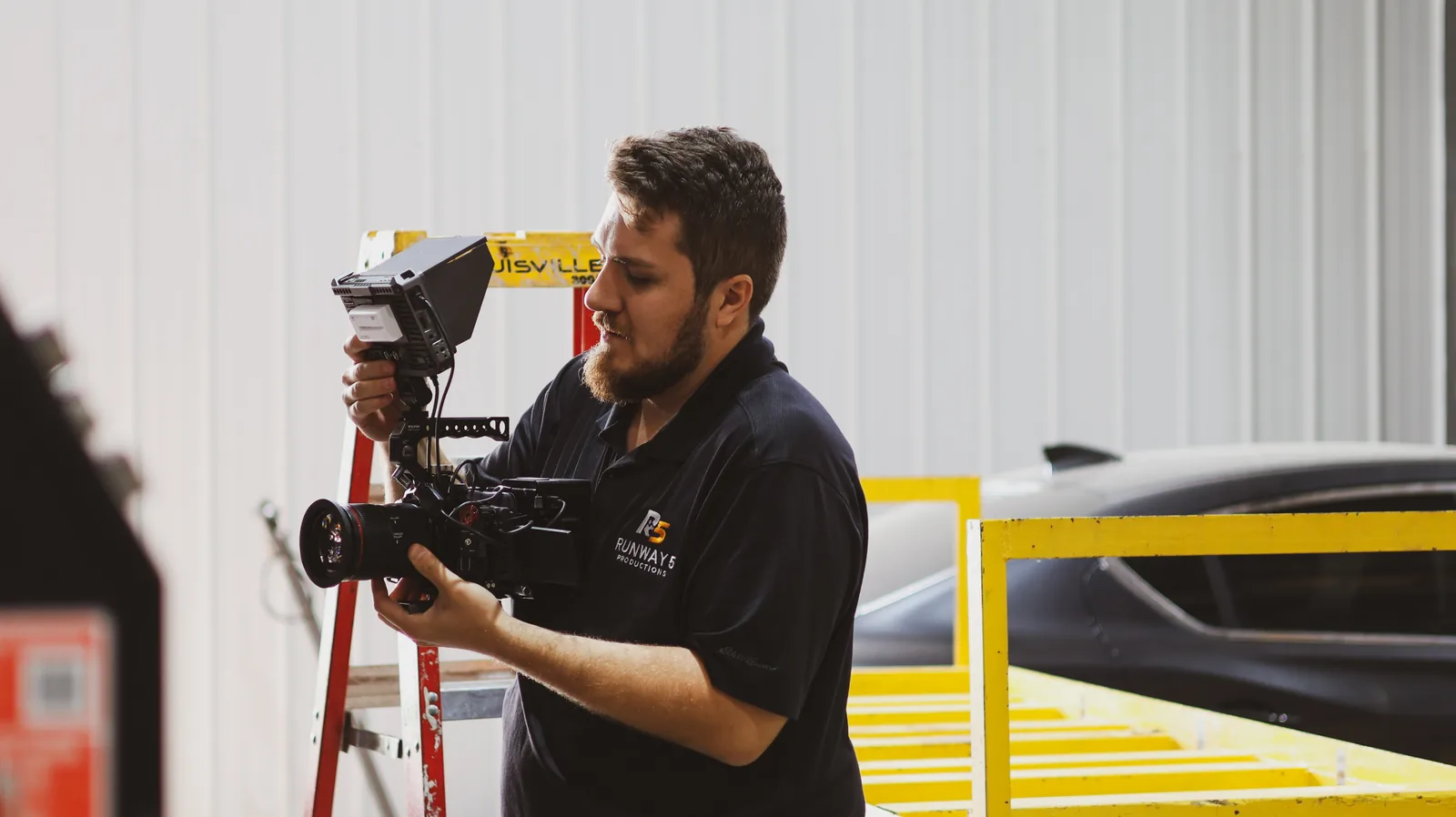 Crew member checking a monitor mounted to a cinema camera rig