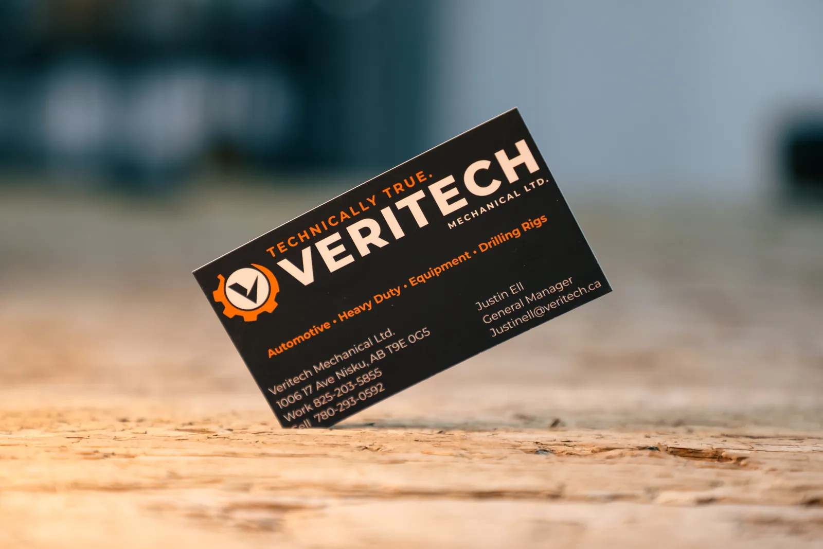 Veritech Mechanical business card standing on a wooden surface