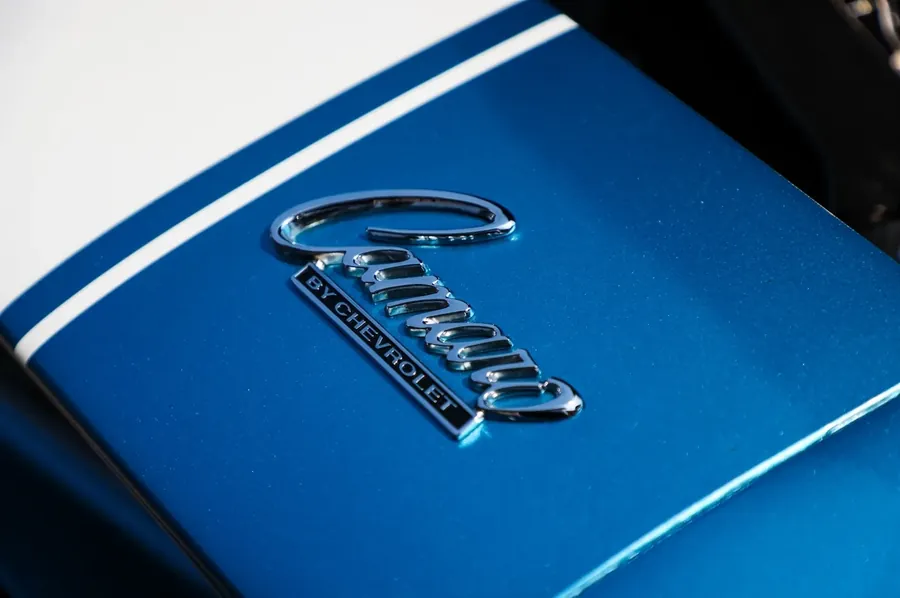 Chrome script badge on a blue hood beside a white racing stripe