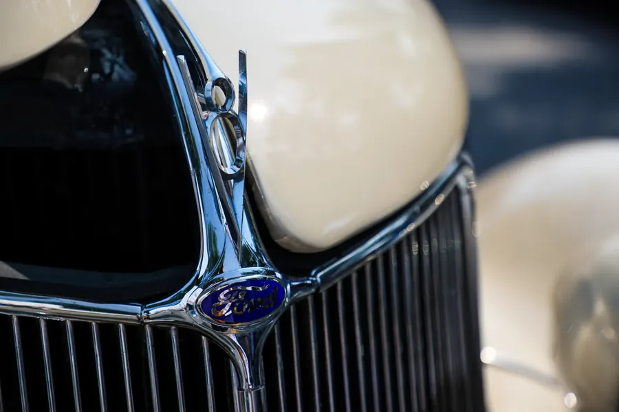 Chrome grille and V8 badge on a classic cream-coloured car