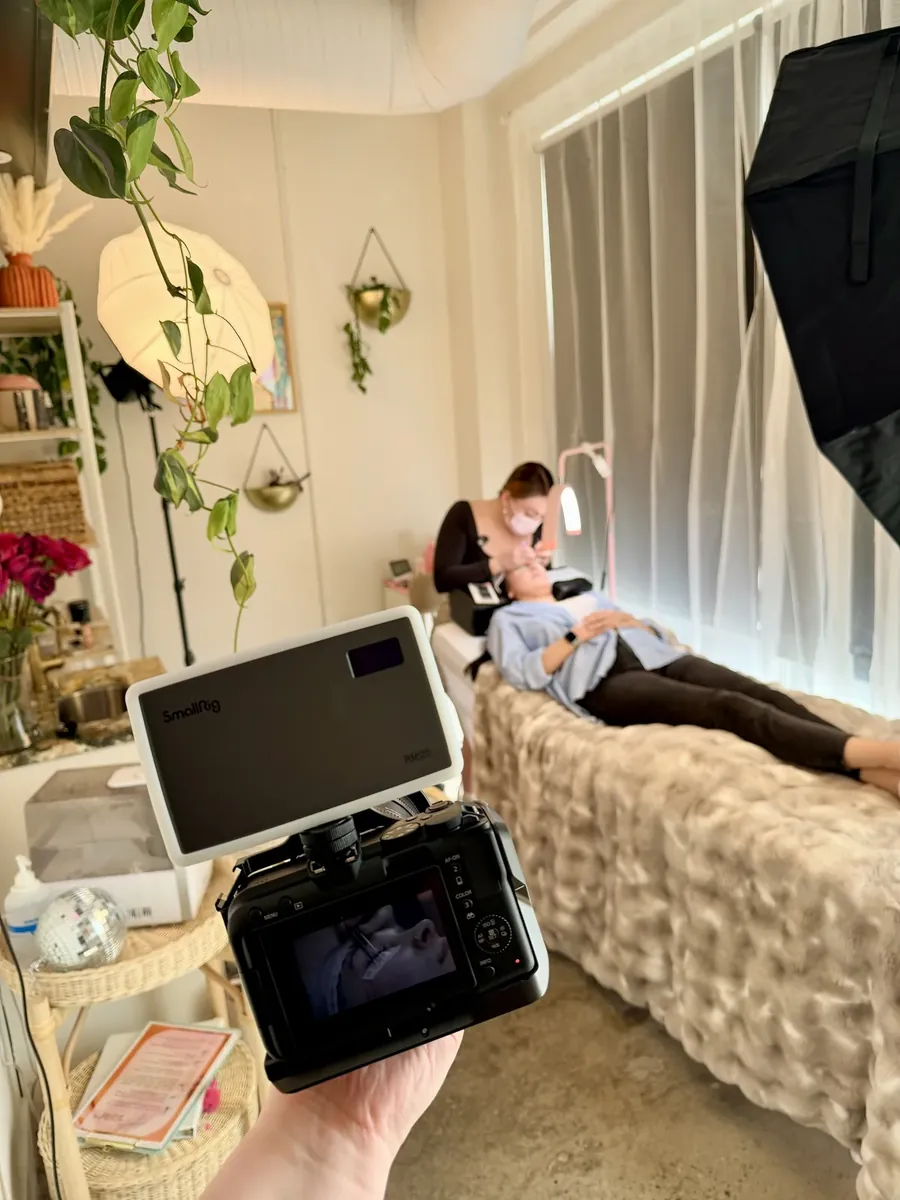 Camera monitor framing a lash appointment in a bright studio