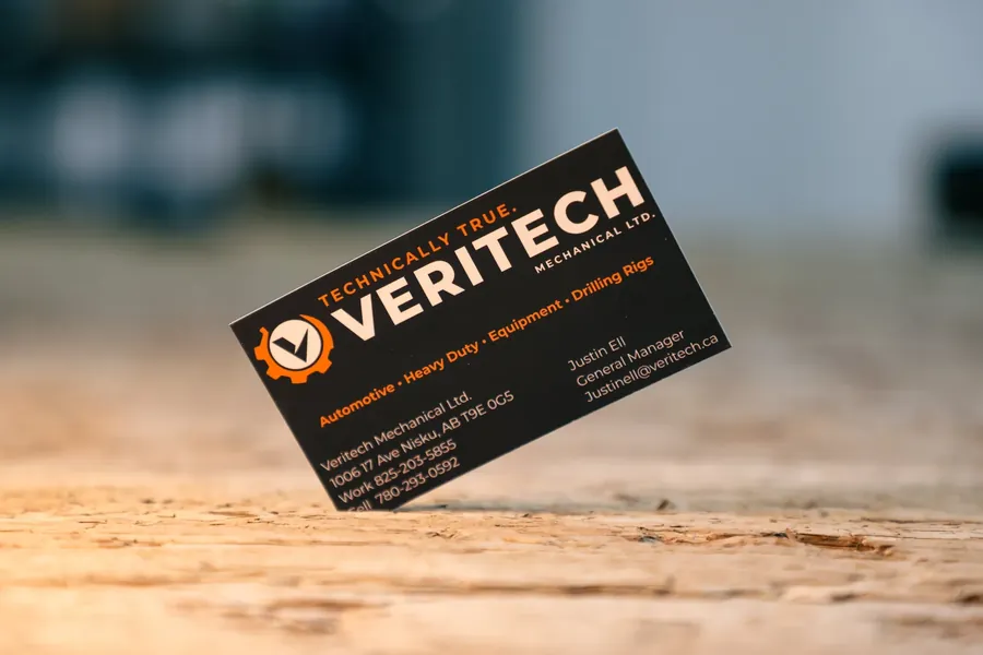 Veritech Mechanical business card standing on a wooden surface